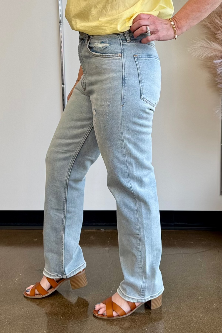 Close up side view of a woman wearing a light wash denim with a relaxed fit.