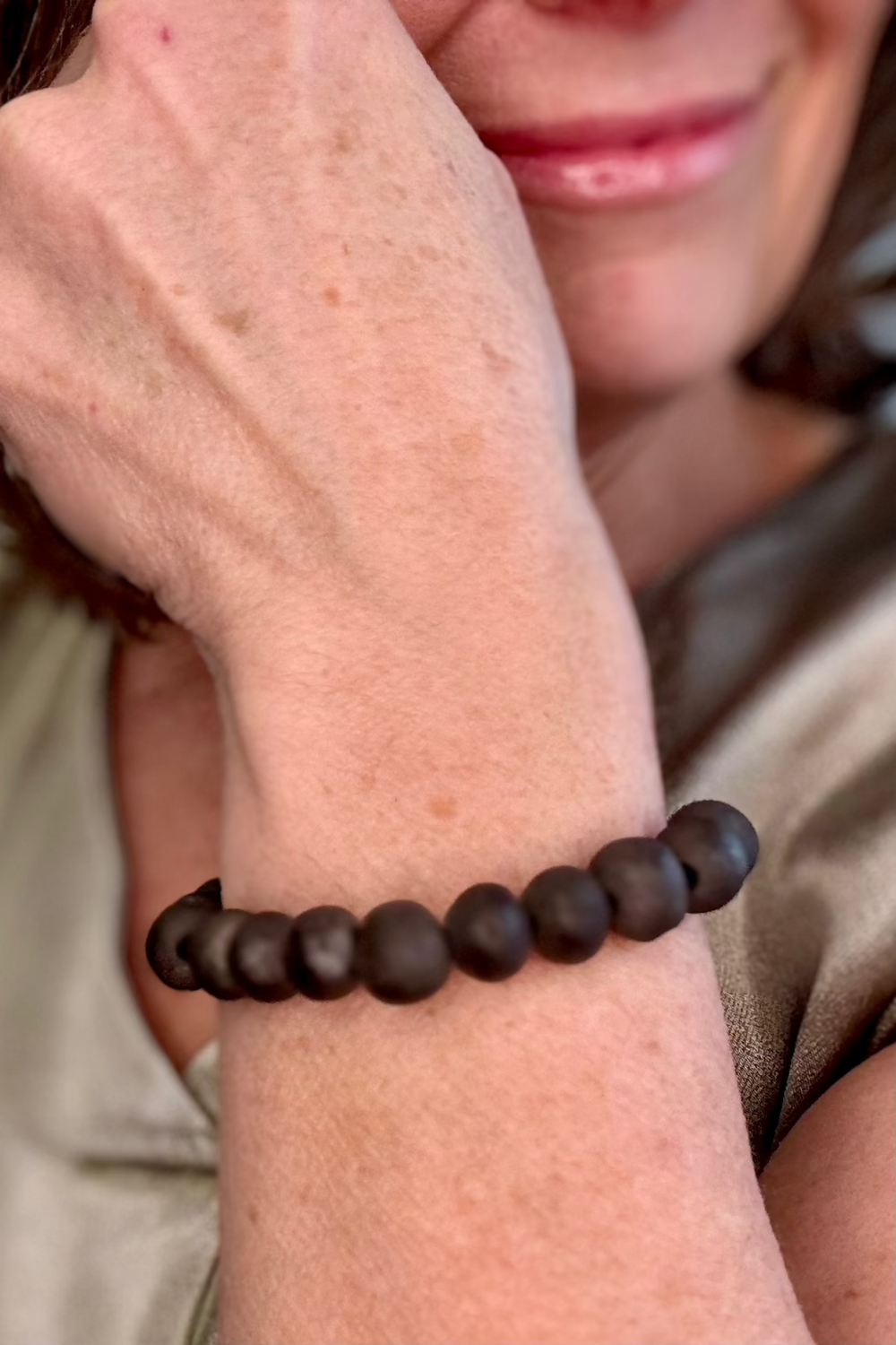 Close up of a round black beaded bracelet.