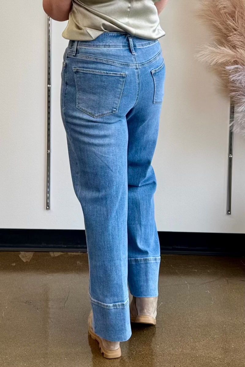 Full length rear view of a medium wash denim with a wide cuff.