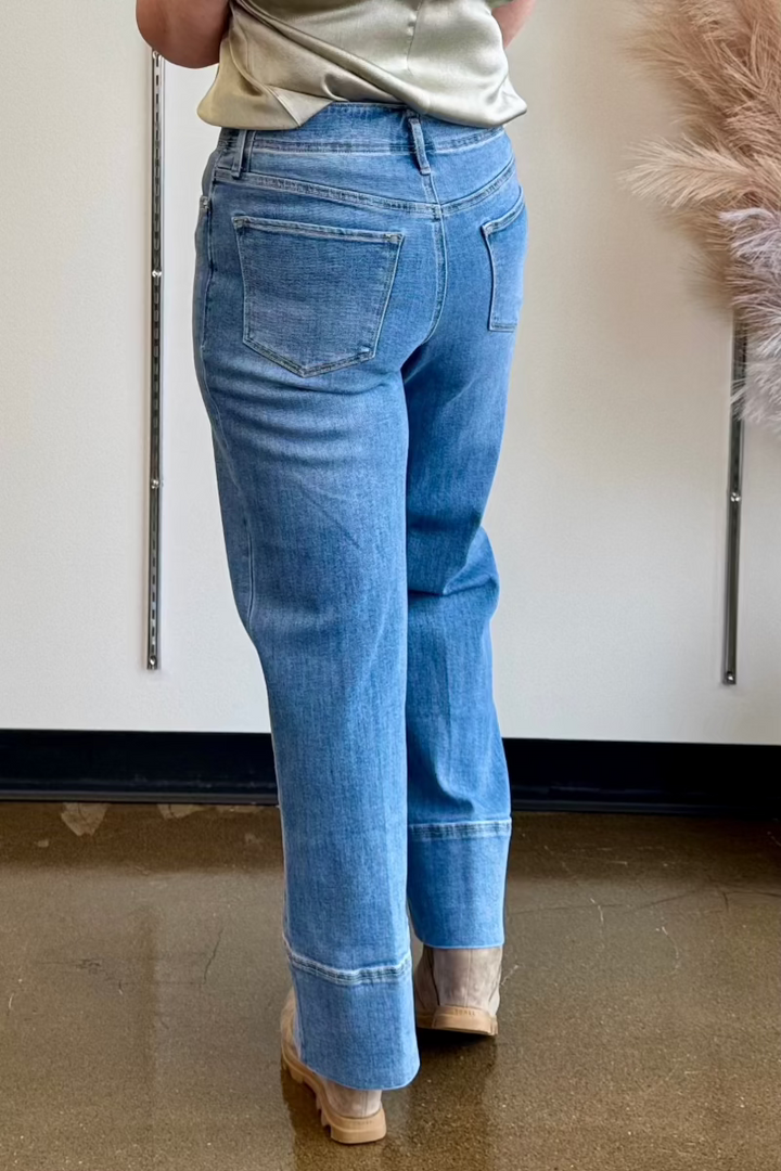 Full length rear view of a medium wash denim with a wide cuff.