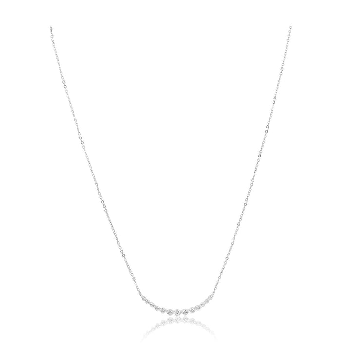 Close-up of the Imani CZ Dainty Necklace showing the delicate chain and sparkling CZ stones set in a line, against a reflective, white background.