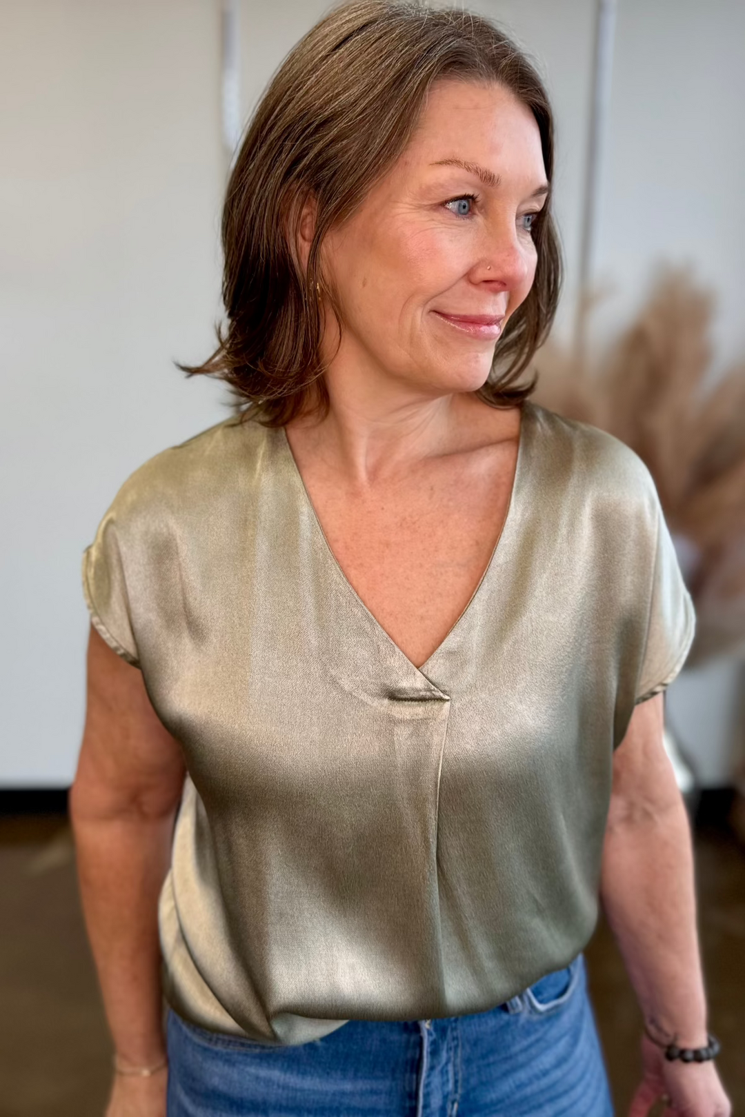 Close up of woman wearing a silky v-neck top.