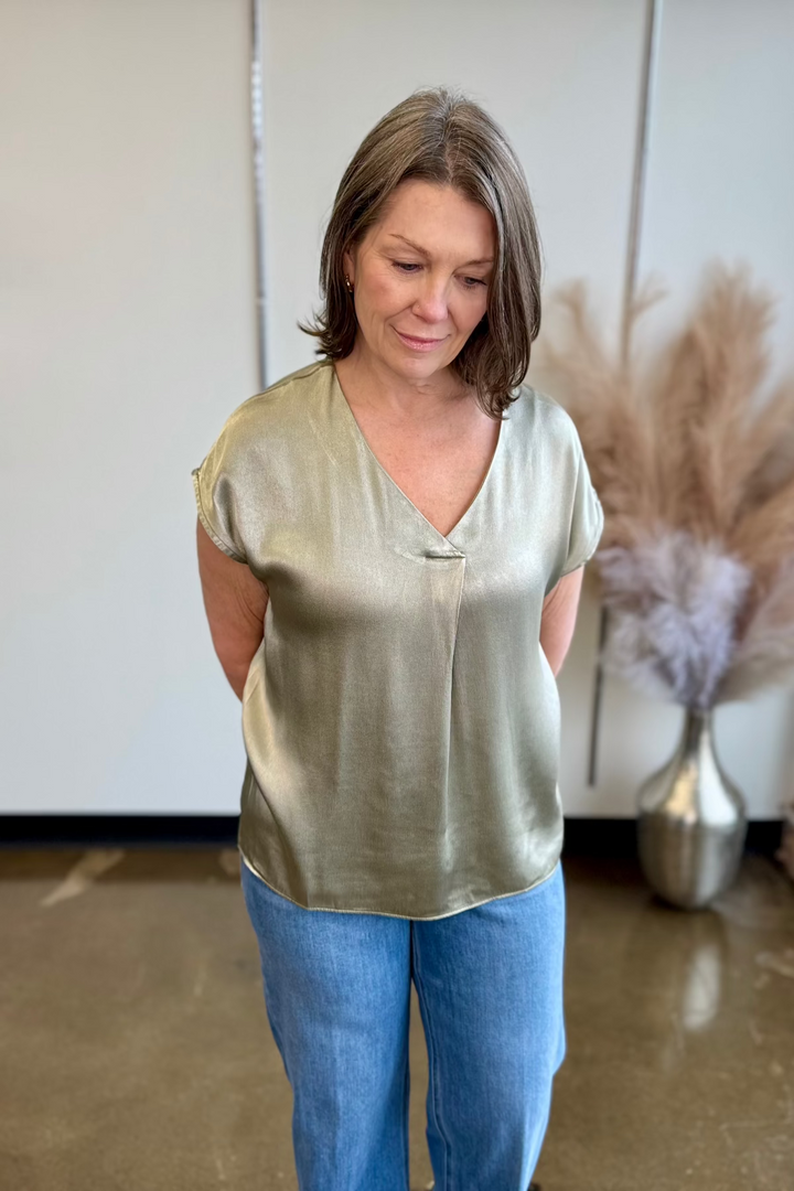 Close up view of woman wearing a v-neck blouse showing the length of the top.